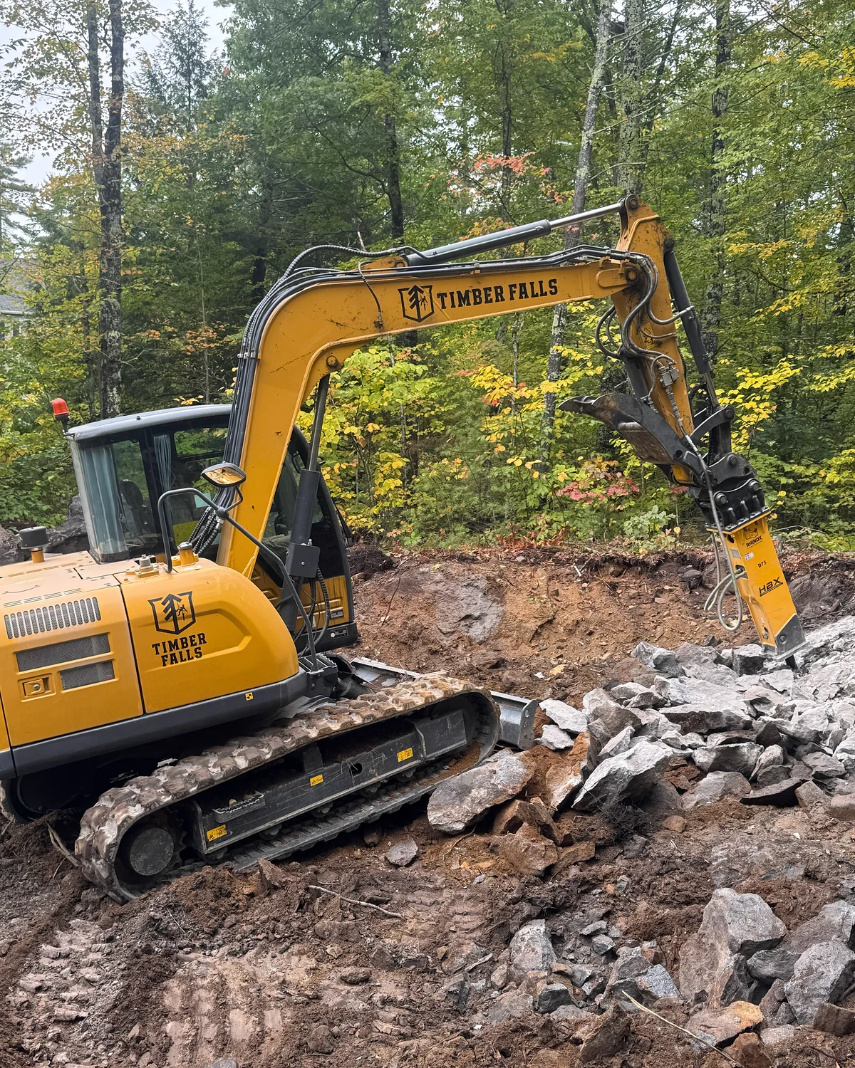Timber Falls excavator breaking rock during site work